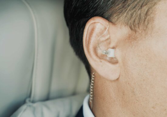 Ho much does it costs to hire a bodyguard | Infinite Risks International | Close-up of a security agent wearing an earpiece in a professional setting.