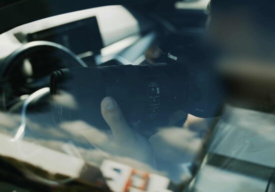 Covert Surveillance Services | Infinite Risks International | A photographer holding a camera inside a car, capturing reflections.