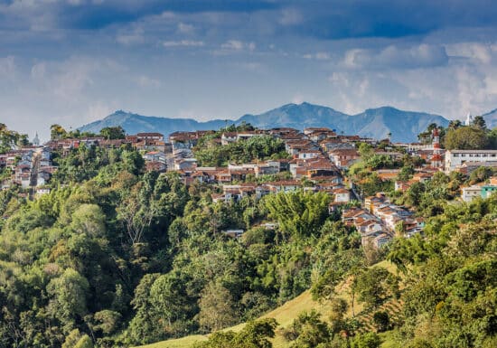 Executive Protection in South America. A hillside town in Colombia surrounded by greenery and mountains.