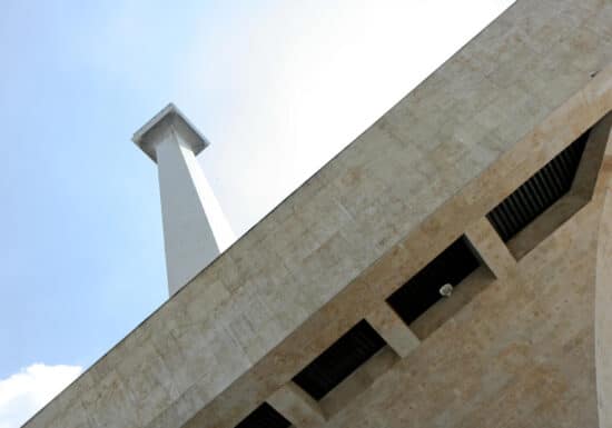 Bodyguard services in Indonesia. A low-angle view of a tall white monument against a clear blue sky.