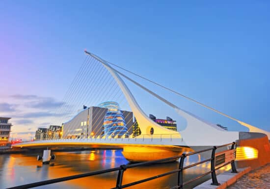 Bodyguard services in Ireland. A modern, illuminated bridge in Dublin, Ireland, at dusk.