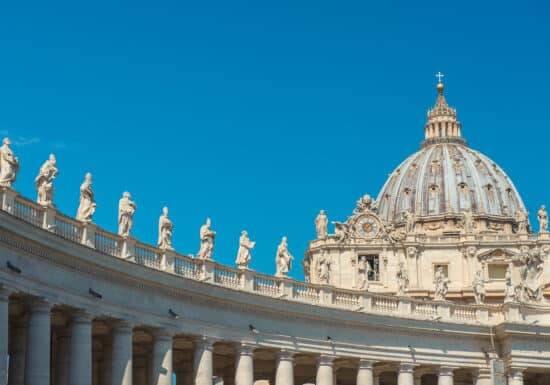 Bodyguard services in Italy. The dome of St. Peter's Basilica in Vatican City with statues on the colonnade.