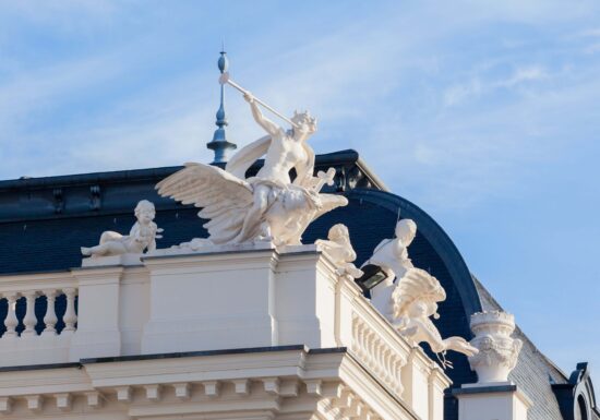 Bodyguard services in Switserland. Ornate white sculptures of figures and animals on the rooftop of a historic building in Switzerland.