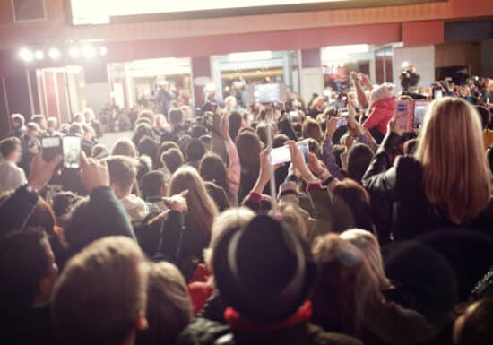 Celebrity Protection Services. A crowded celebrity event with a large audience taking photos with their smartphones.