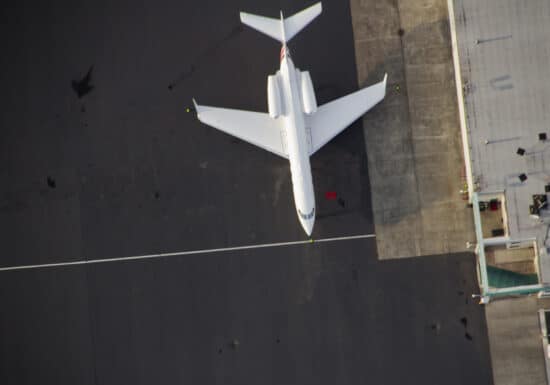 Corporate Travel Security. Aerial view of a private jet parked on an airport tarmac.