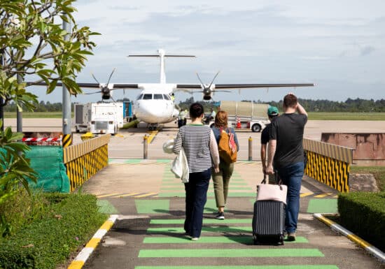 Global Evacuation Services. Passengers walking towards a small passenger plane on an airport tarmac.