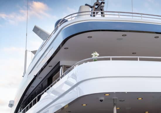 Yacht Event Security Services. The sleek upper deck of a luxury yacht with polished white surfaces and a clear blue sky above.