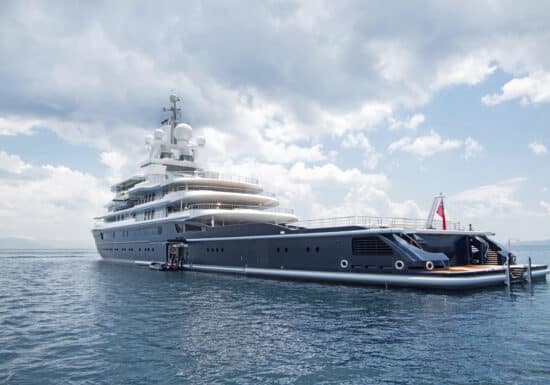 Yacht Protection Services. A large luxury yacht anchored in calm waters, with a cloudy sky in the background.