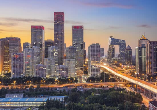 Bodyguard services in Beijing. A city skyline at dusk with illuminated skyscrapers and busy streets.