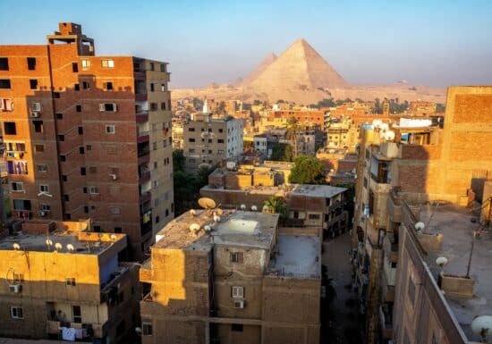 Bodyguard services in Egypt. Cairo's cityscape with buildings and the Pyramids of Giza in the background.