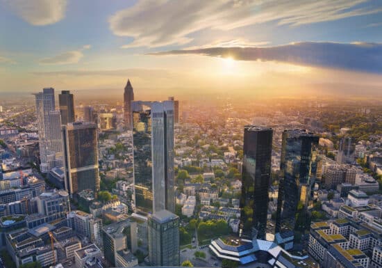 Bodyguard Services in Germany. Sunset over a modern city with skyscrapers bathed in golden light.