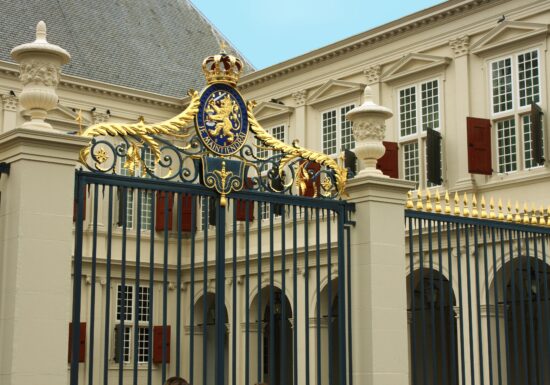 Royal Bodyguard Services. Front gate of the Dutch Royal Palace in The Hague, adorned with the royal coat of arms.