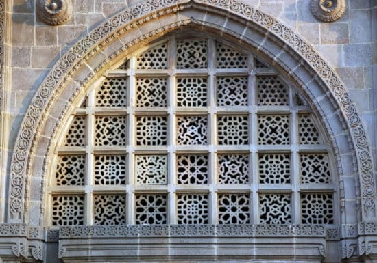 Bodyguard services in Mumbai. Ornate arched window with intricate lattice patterns and stone carvings.