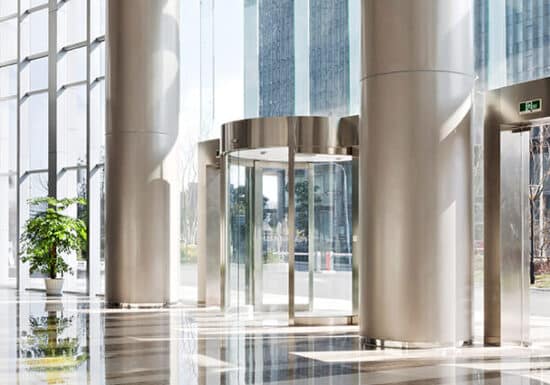 Penetration Testing Travel Risk Management. A bright, modern lobby with glass doors and tall windows, featuring potted plants.